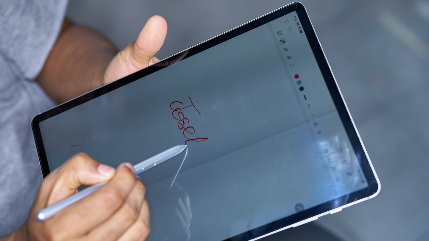 A person writes the word test on a digital tablet.